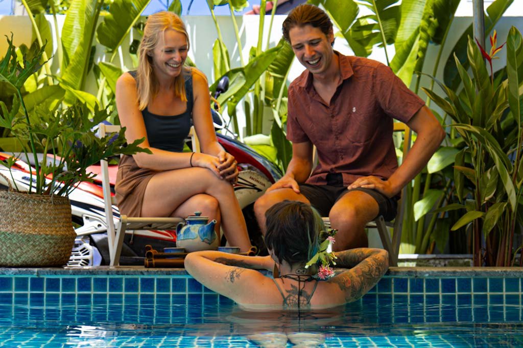 Gäste lachen gemeinsam am Pool des Nalani Hostels