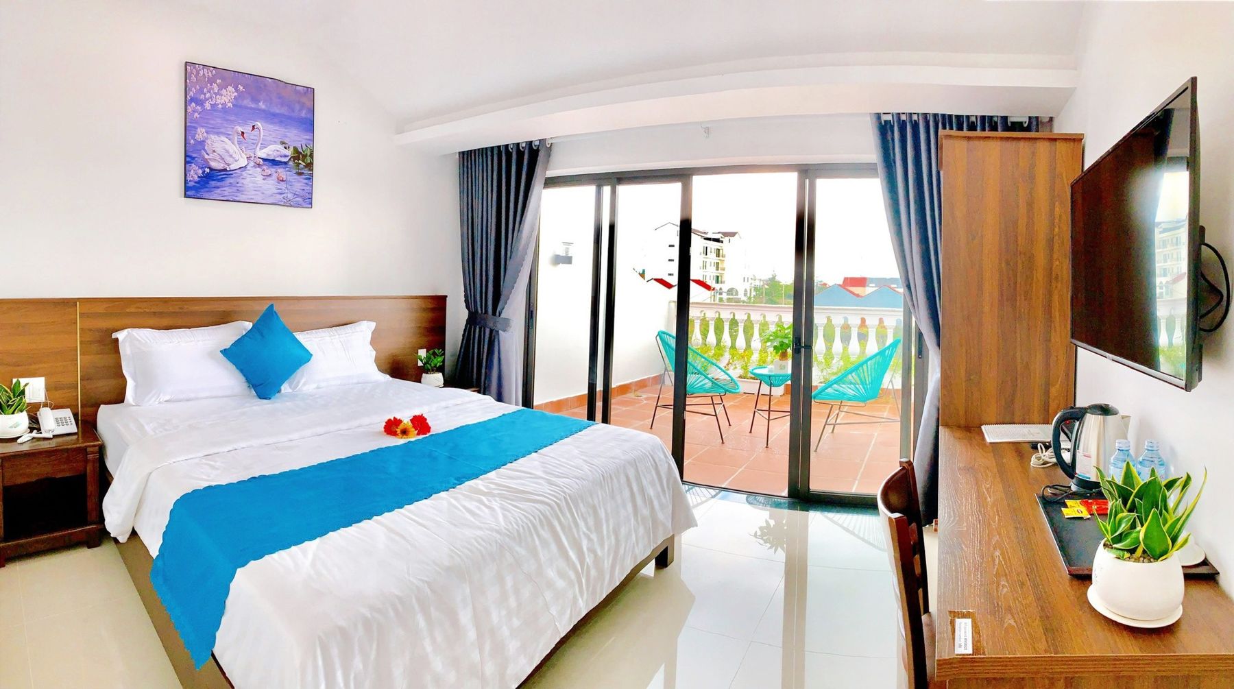 De-Luxe-Doppelzimmer mit blauem Bettläufer und Balkontür