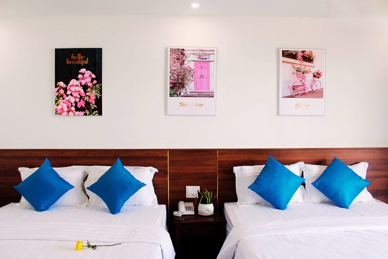 Zimmer mit drei Queen-Size-Betten und Bildern an der Wand